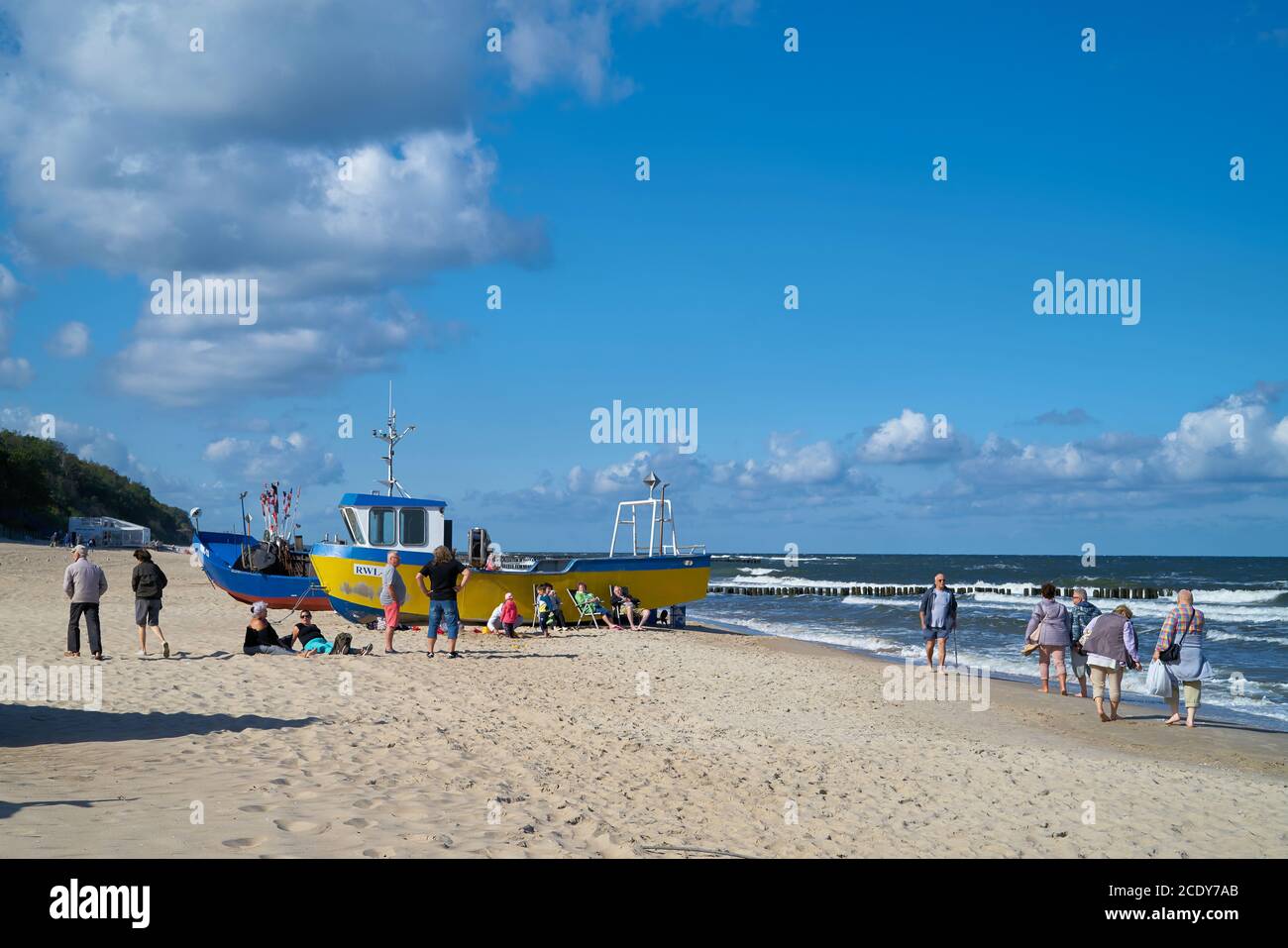 Holidaymakers and fishing boats on the beach of Rewal on the Polish Baltic Sea coast Stock Photo