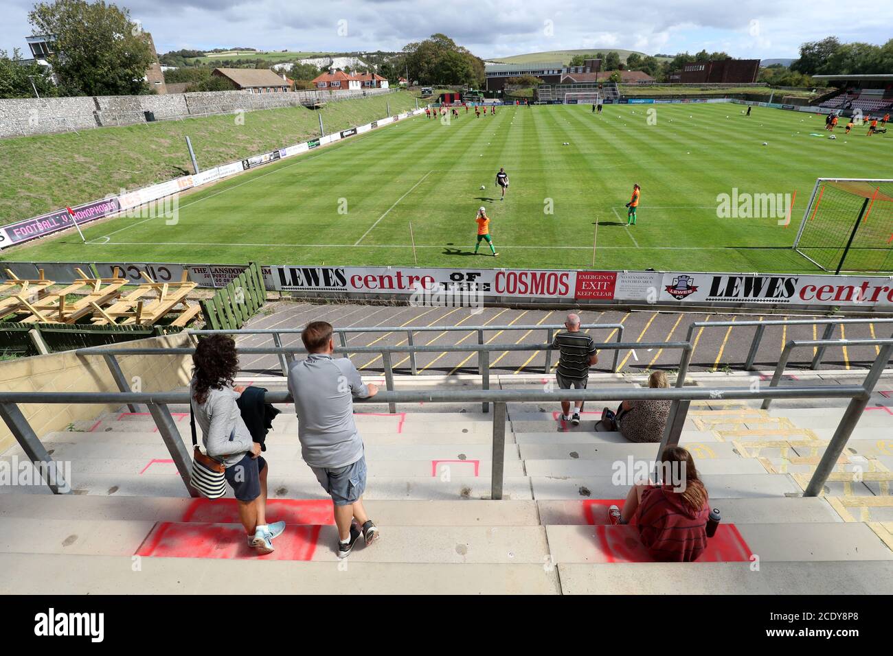 Spectators stand in their designated areas as players warm up during