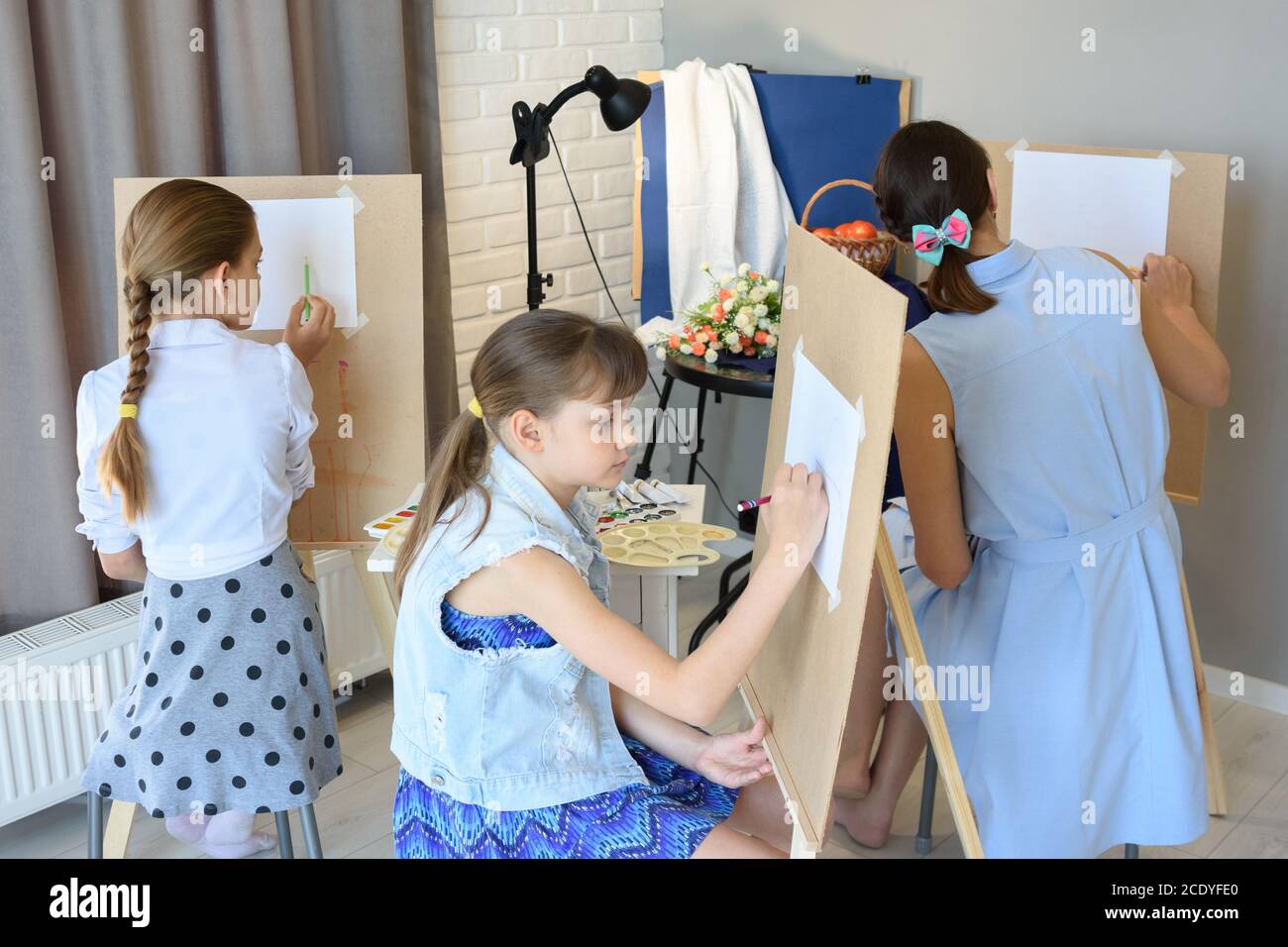 classes in the art studio behind the easels of children and adults Stock Photo
