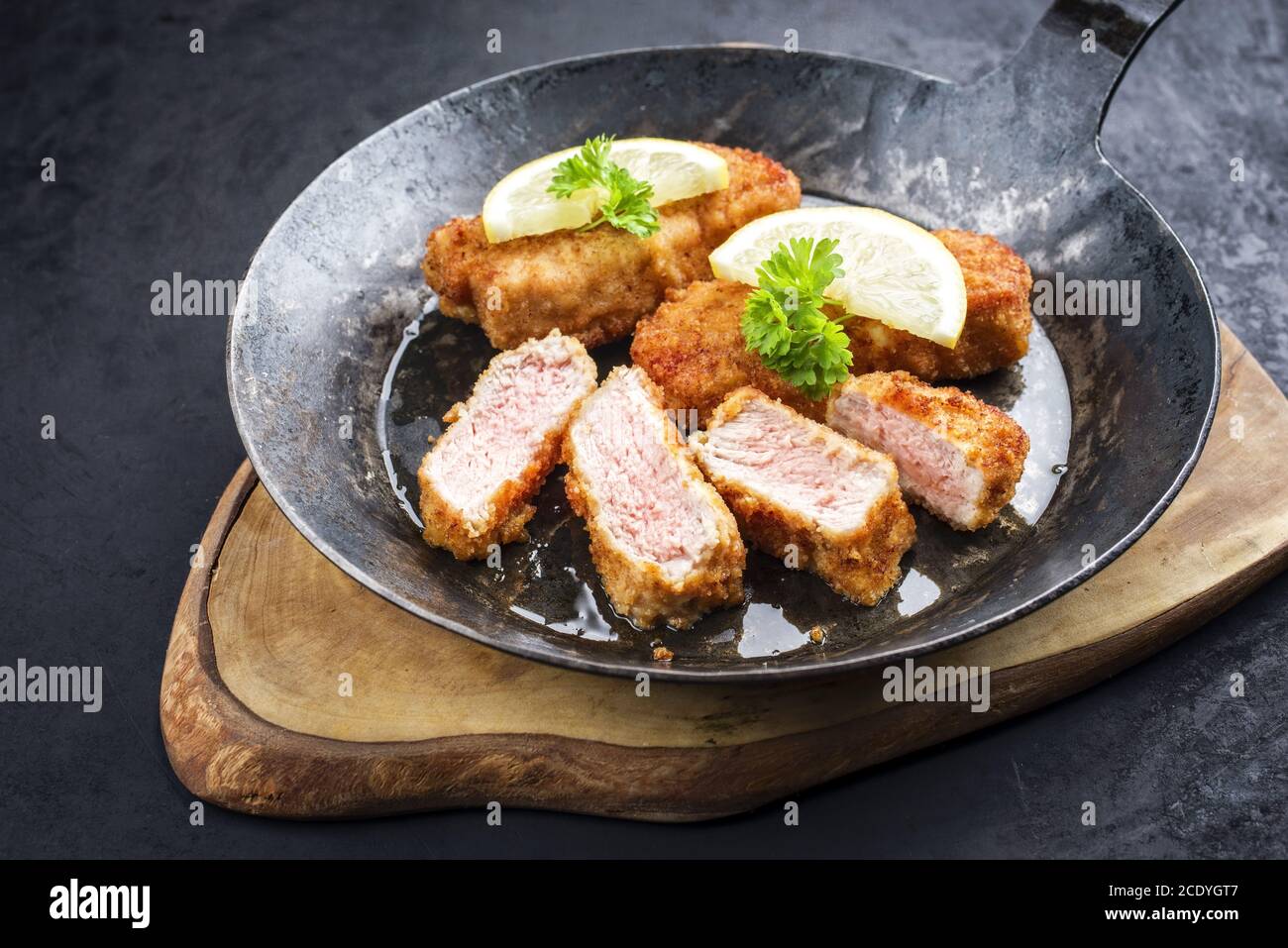 Traditional deep fried veal steak with lemon slices and herbs offered