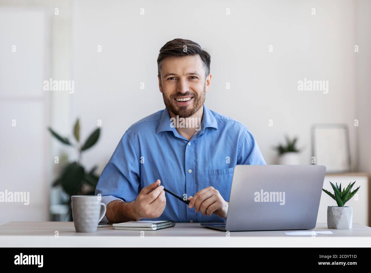Recruitment Concept. Friendly Male HR Manager Sitting At Workplace In Modern Office Stock Photo