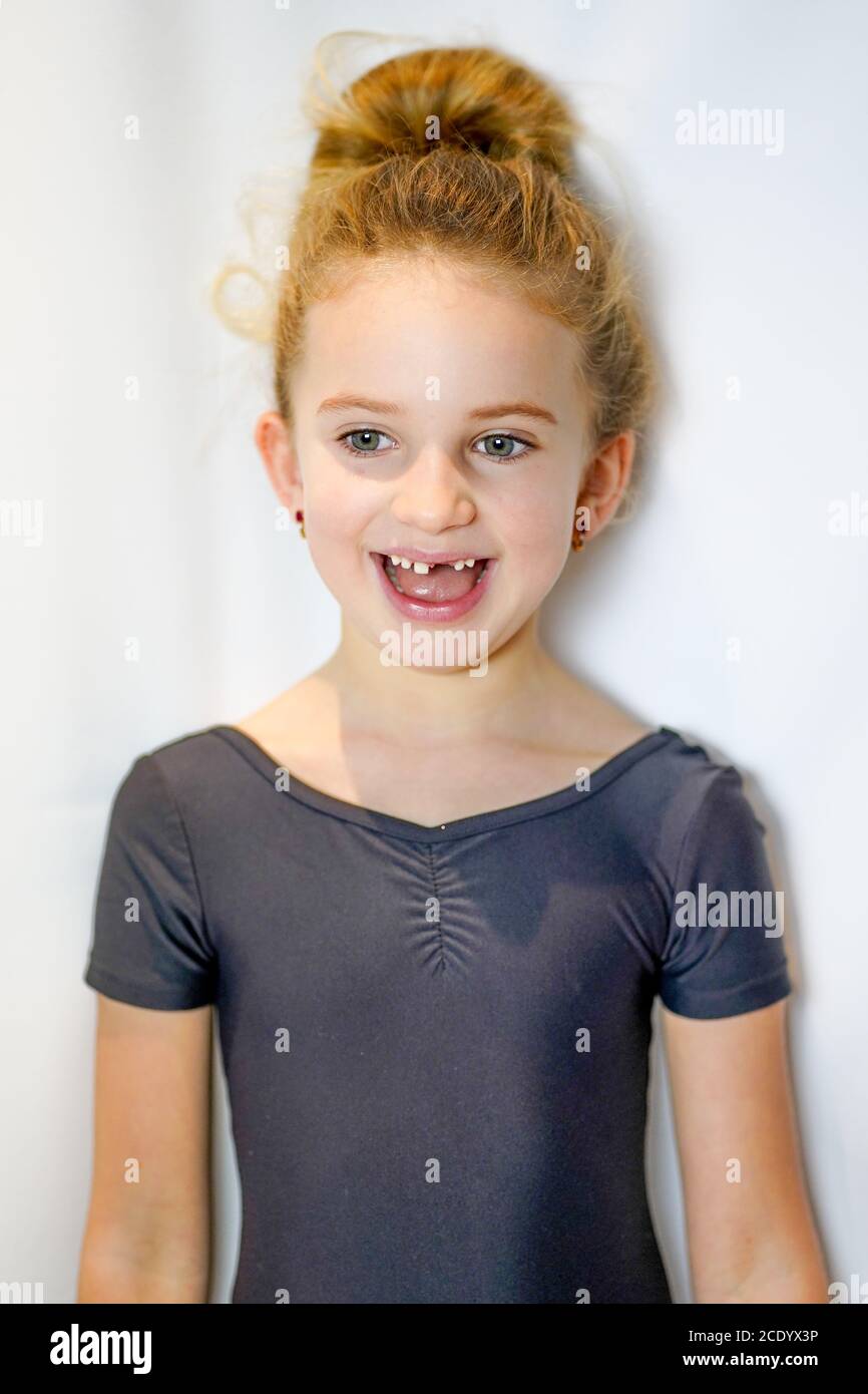 Girl rejoices at the first milk tooth that falls out and waits for the tooth fairy. The child lost a tooth. High quality photo Stock Photo