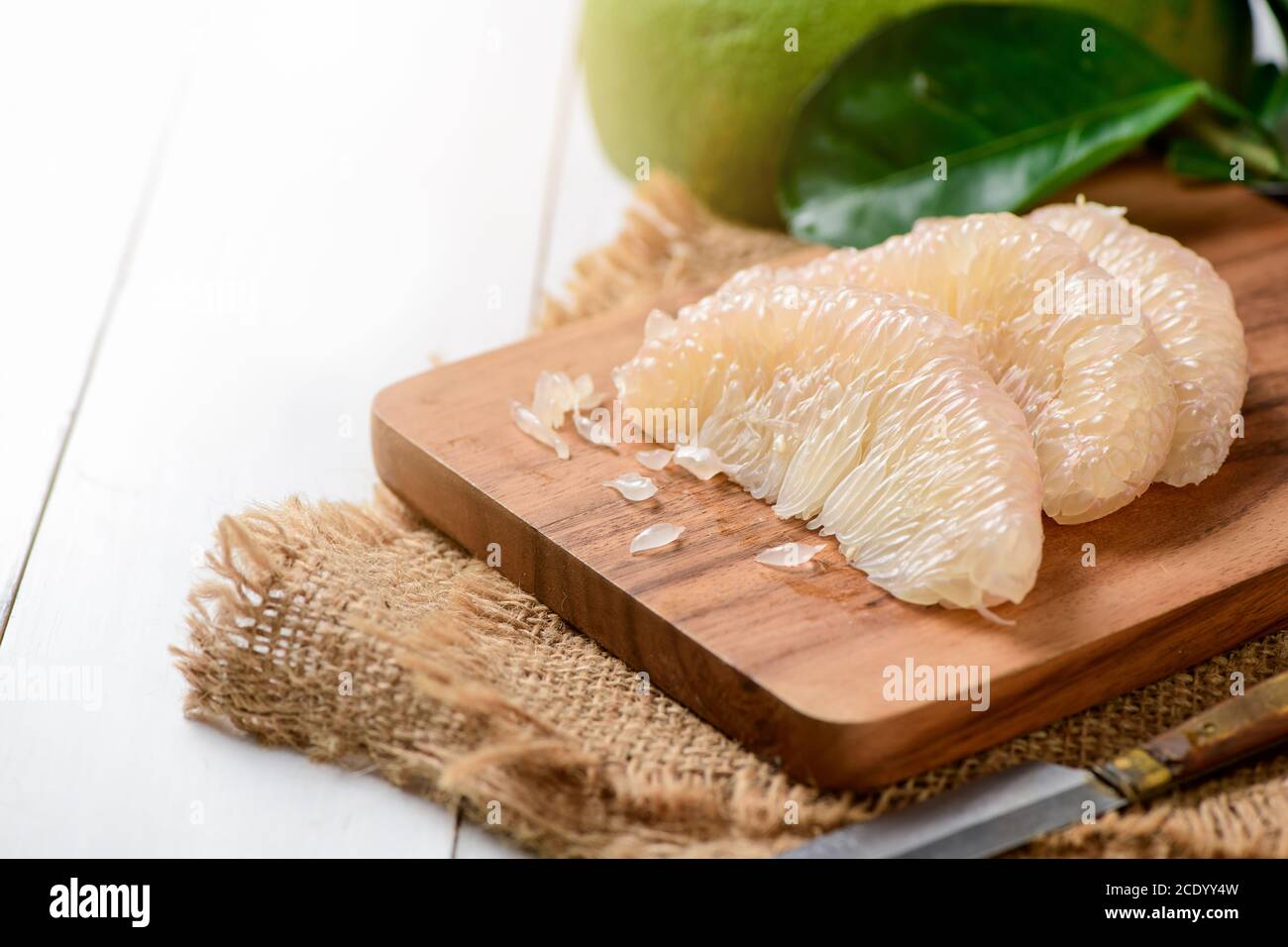 fresh peeled Pomelo or grapefruit on wood plate. Seasonal fruit of