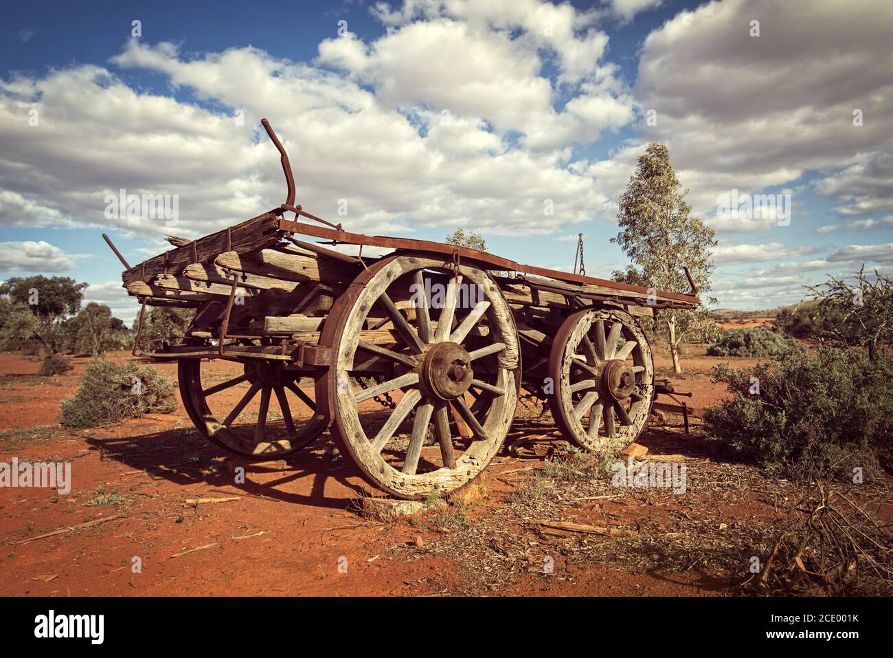 Australia  Outback savanna with an old vintage derelict horse-drawn carriage at the bush under cloudy sky Stock Photo