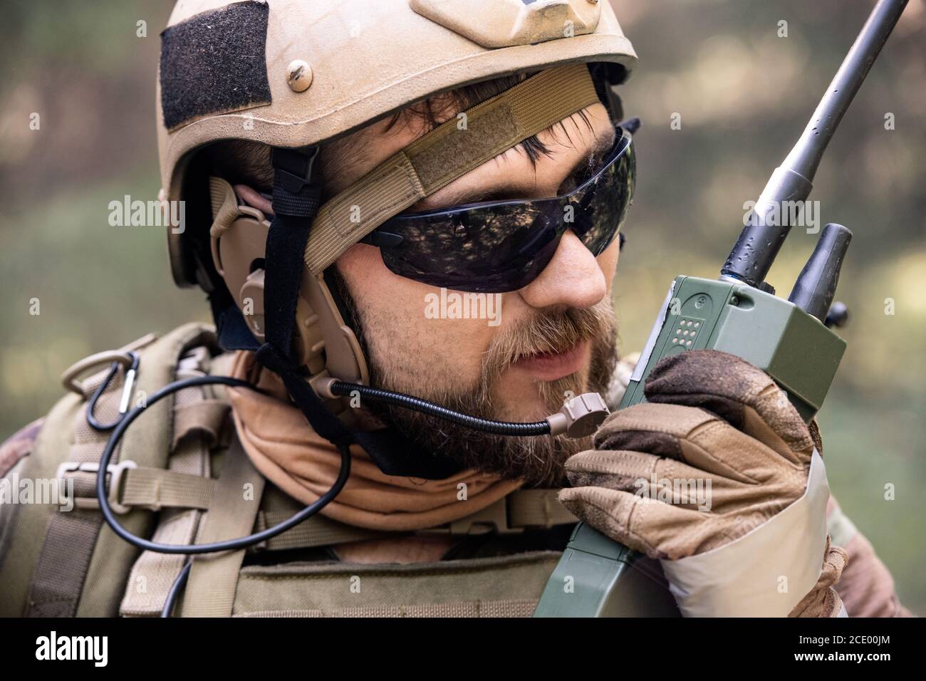 Close-up of bearded soldier in helmet and sunglasses using radio while  taking message to colleague during military operation Stock Photo - Alamy