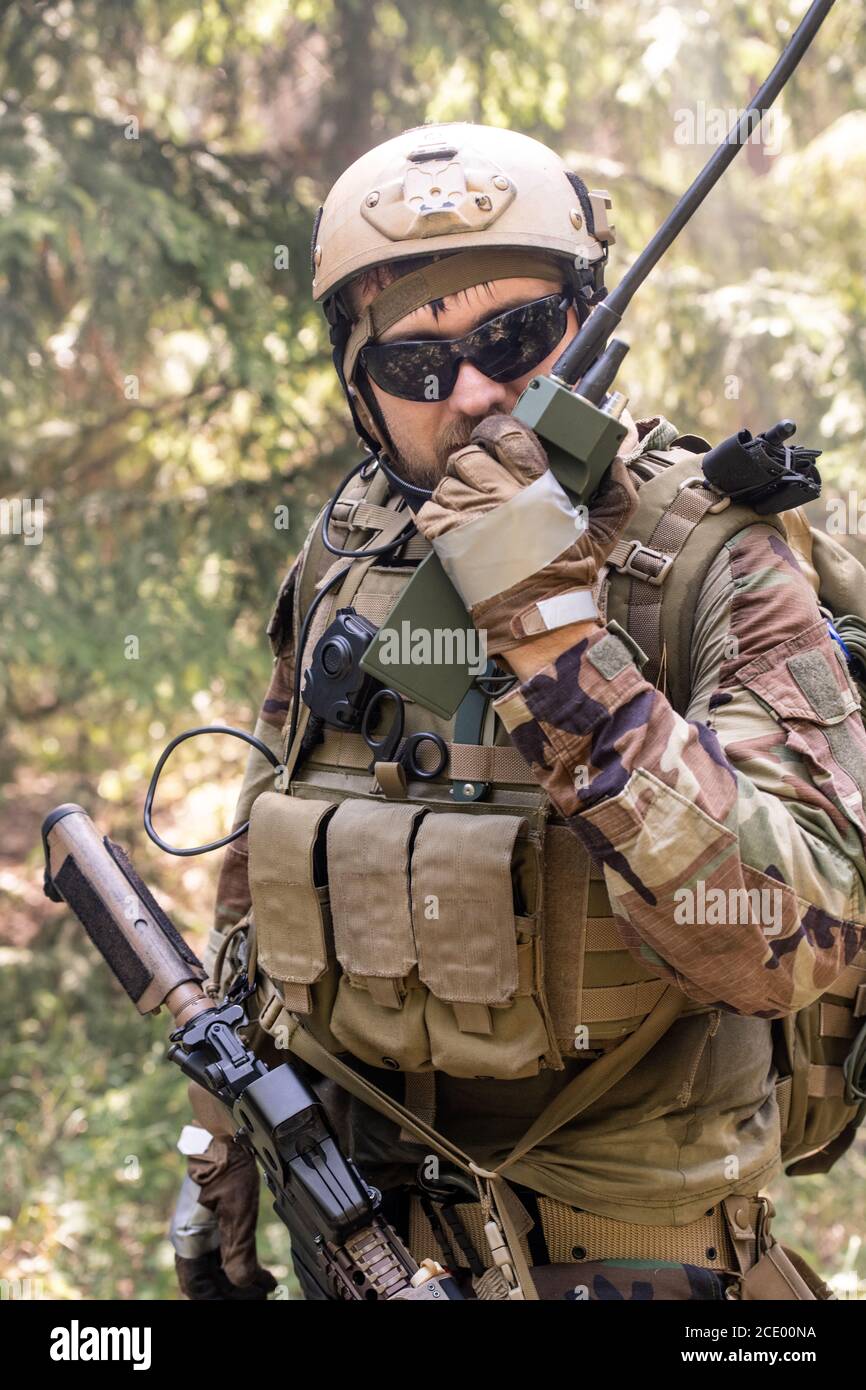 Portrait of soldiers in vest with necessary tools sending message through  walkie-talkie in forest Stock Photo - Alamy