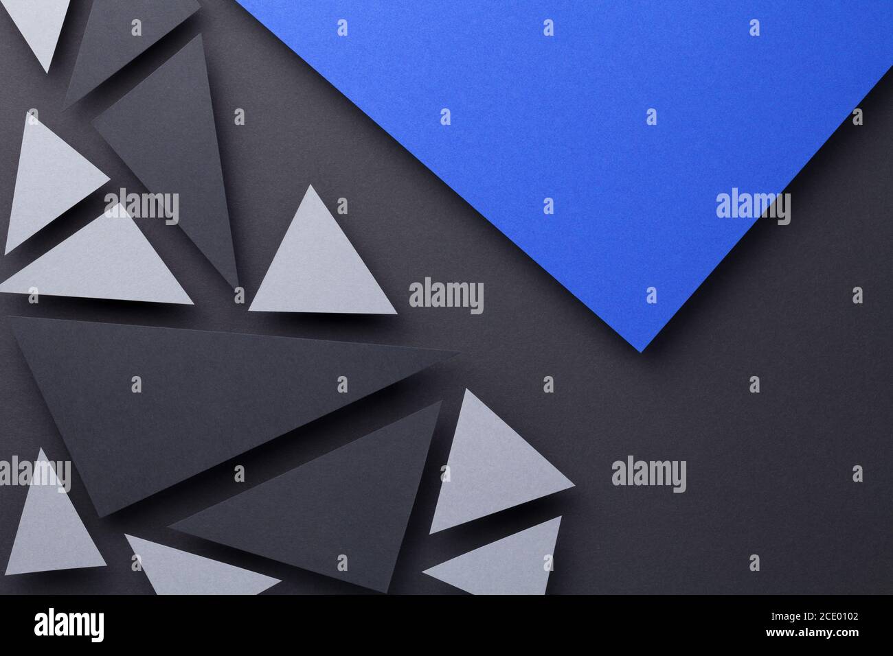 Modern triangular shapes composition over black paper background. Minimal style. Top view Stock Photo