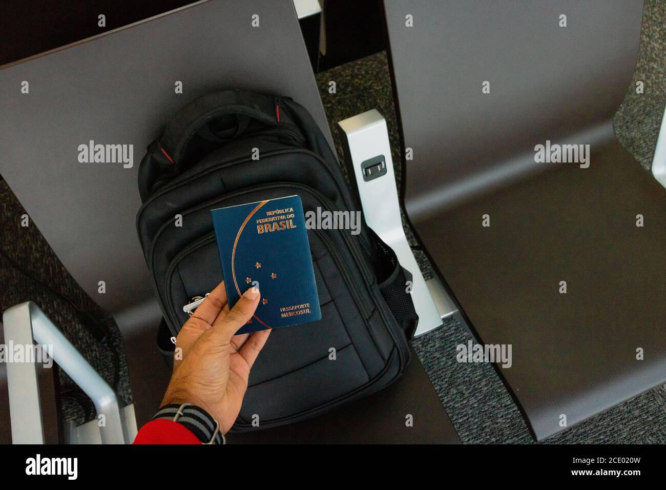 Travel concept image. Holding a brazilian passport, backpack on background. Stock Photo