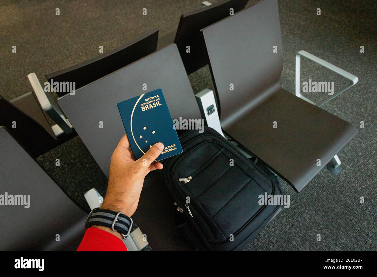 Travel concept image. Holding a brazilian passport, backpack on background. Stock Photo