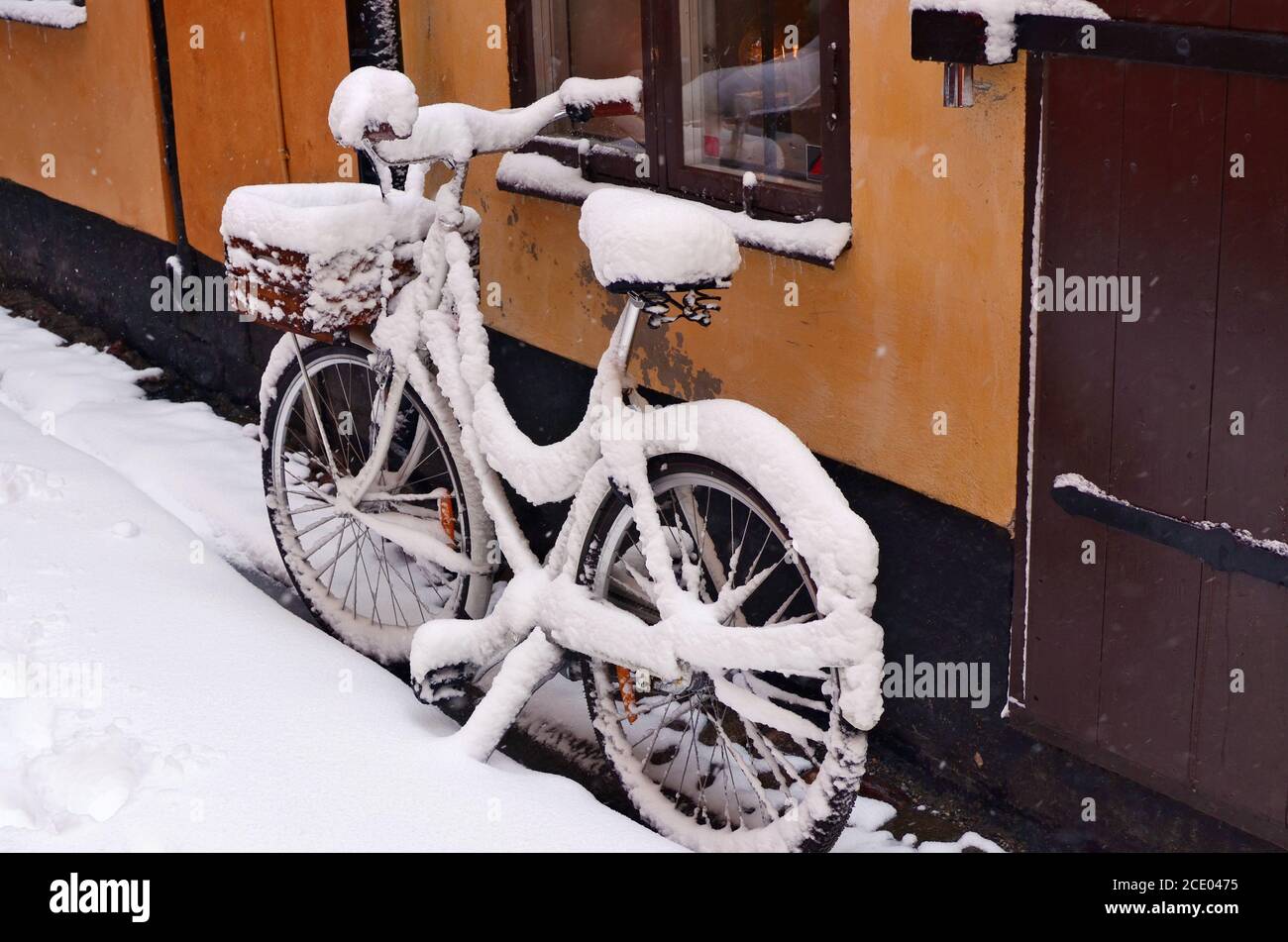 Snowy forgotten old bike on a winter street of an old European city Stock Photo