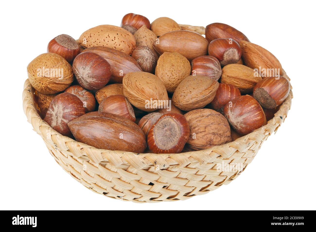 Wicker basket with hazelnuts walnuts almonds and cashew nuts for Christmas table isolated macro Stock Photo