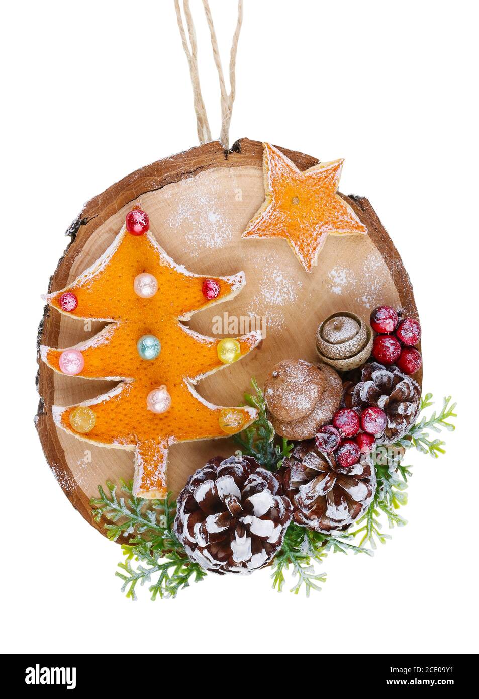 Christmas homemade decoration toy  in rustic style made  of dry red orange peels, cones and  berries and wooden cut slice  isola Stock Photo