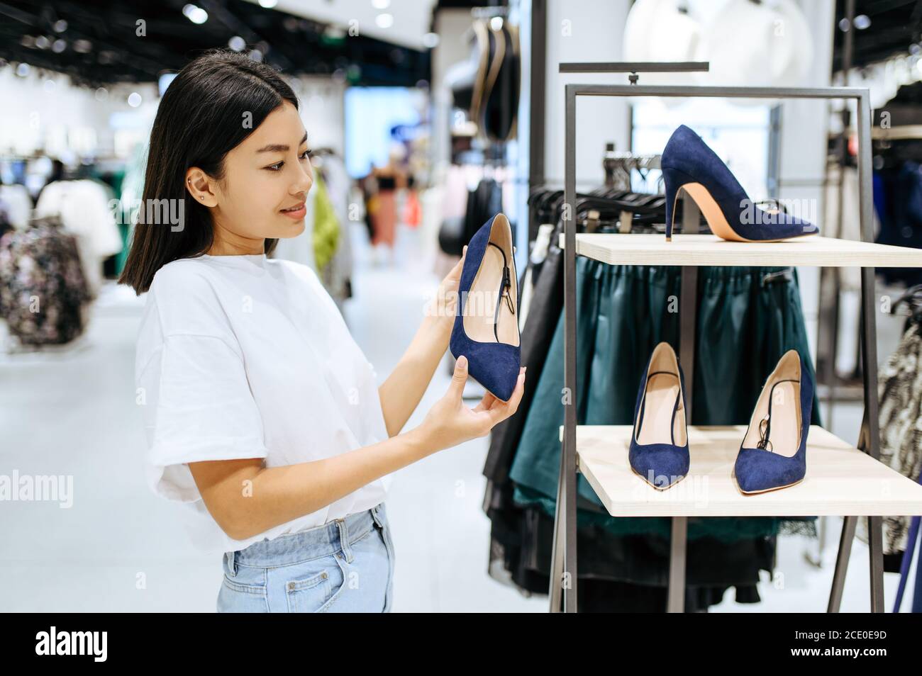 Pretty woman choosing shoes in clothing store Stock Photo - Alamy