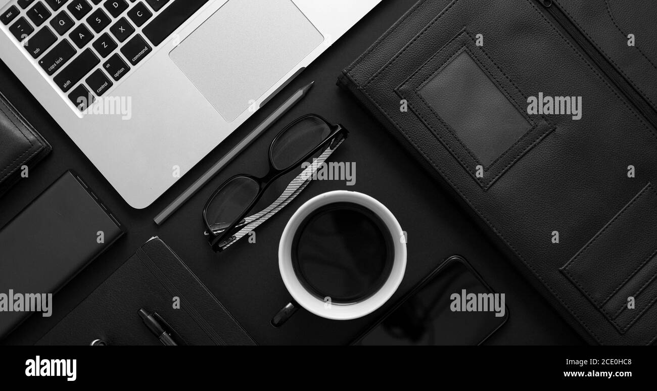 https://c8.alamy.com/comp/2CE0HC8/business-desktop-concept-mix-of-office-supplies-and-gadgets-on-a-black-table-background-2CE0HC8.jpg