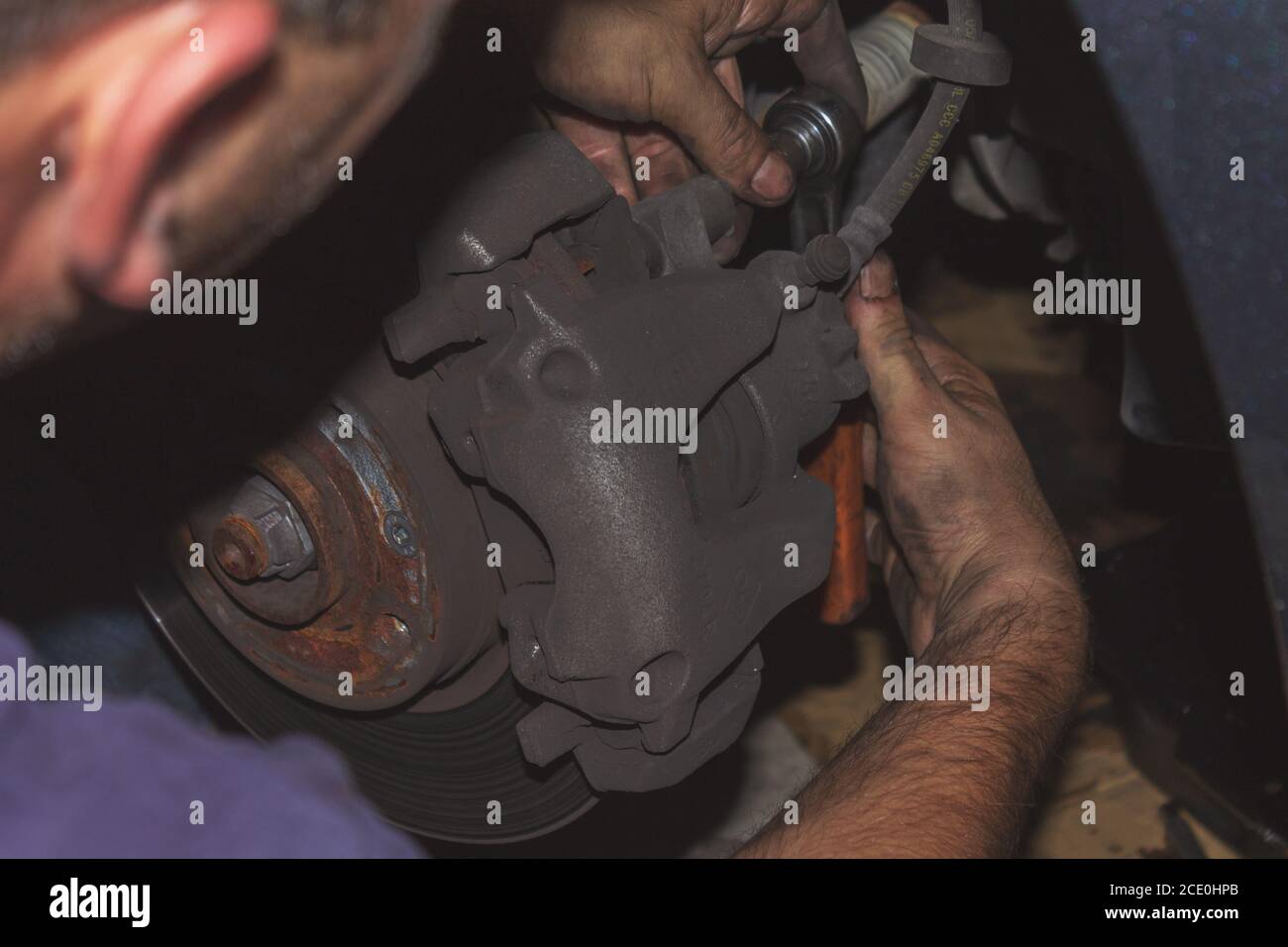 Professional car mechanic changing front brake pads in repair garage Stock Photo