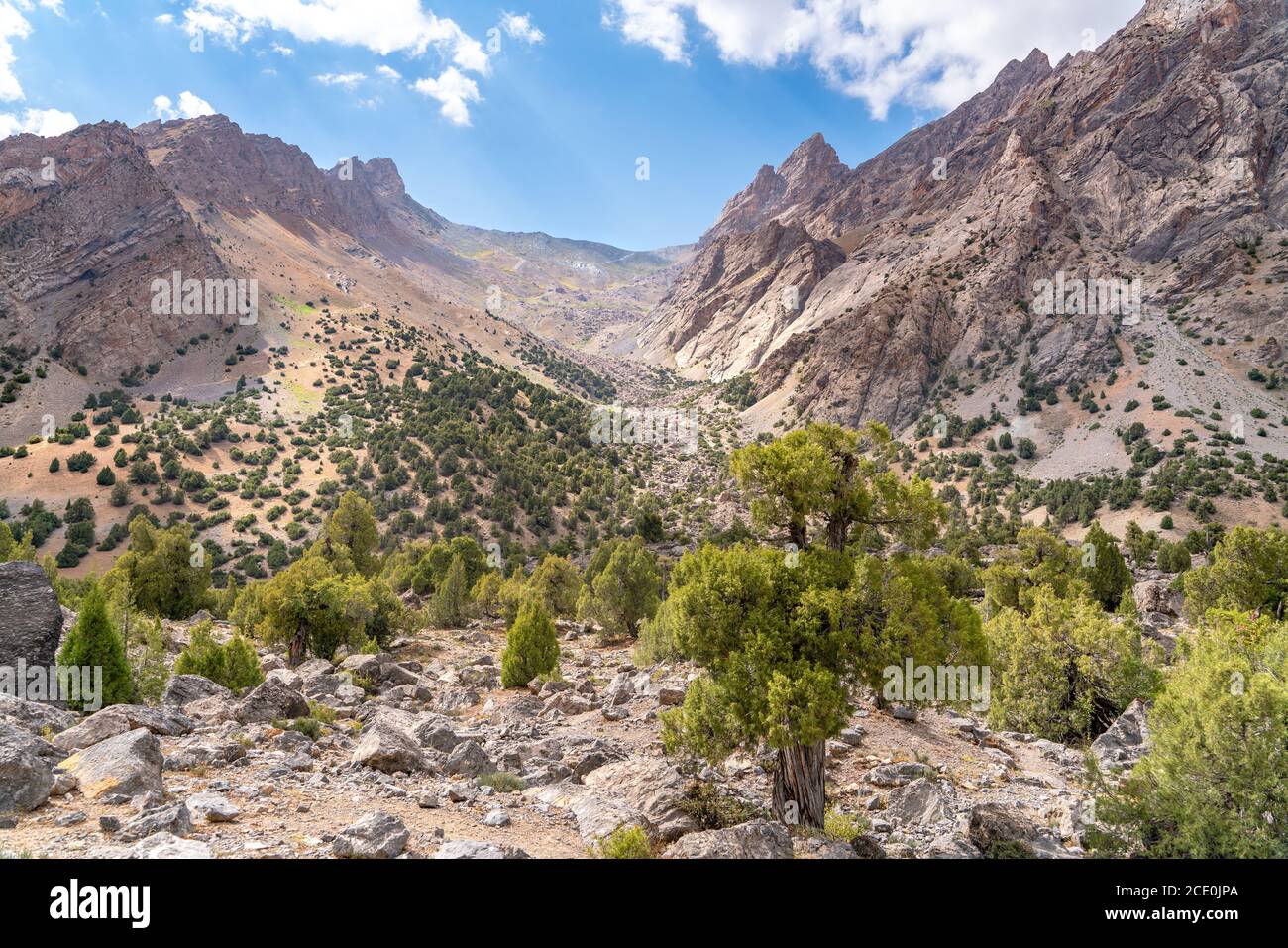 The beautiful mountain trekking road with clear blue sky and rocky hills and fresh mountain stream in Fann mountains in Tajikist Stock Photo