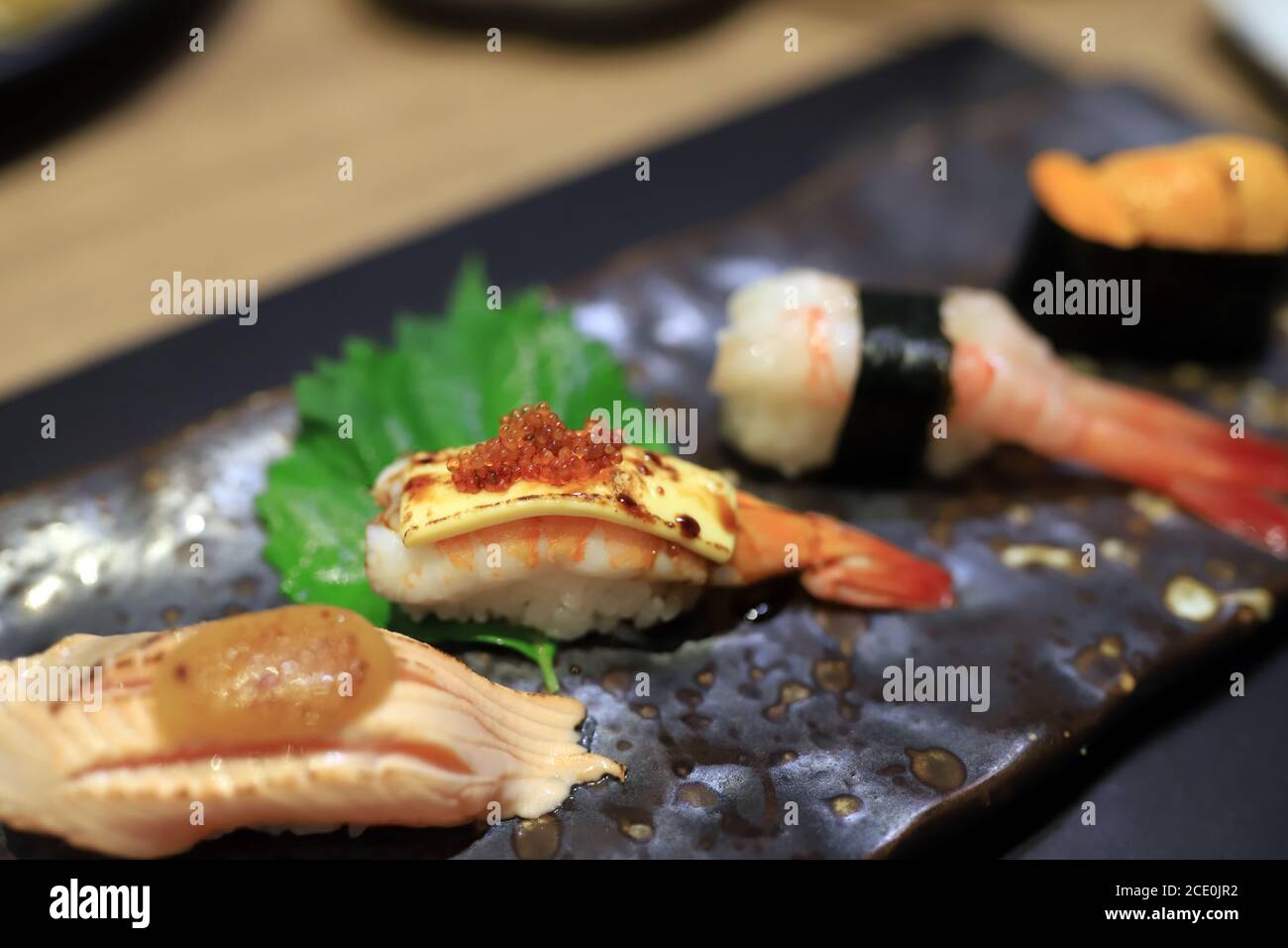 Shrimp sushi topped with grilled cheese and topped with orange roe On a