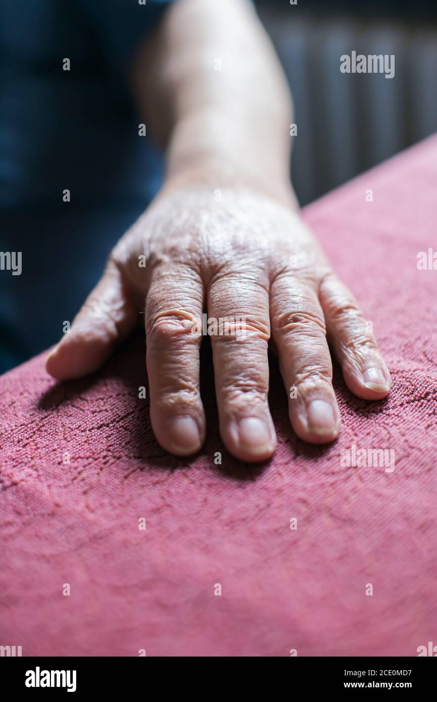 old person's hand resting on table Stock Photo