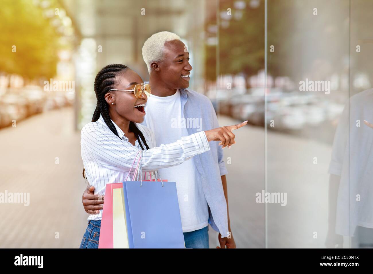 Surprised african american couple saw sale in shop showcase Stock Photo