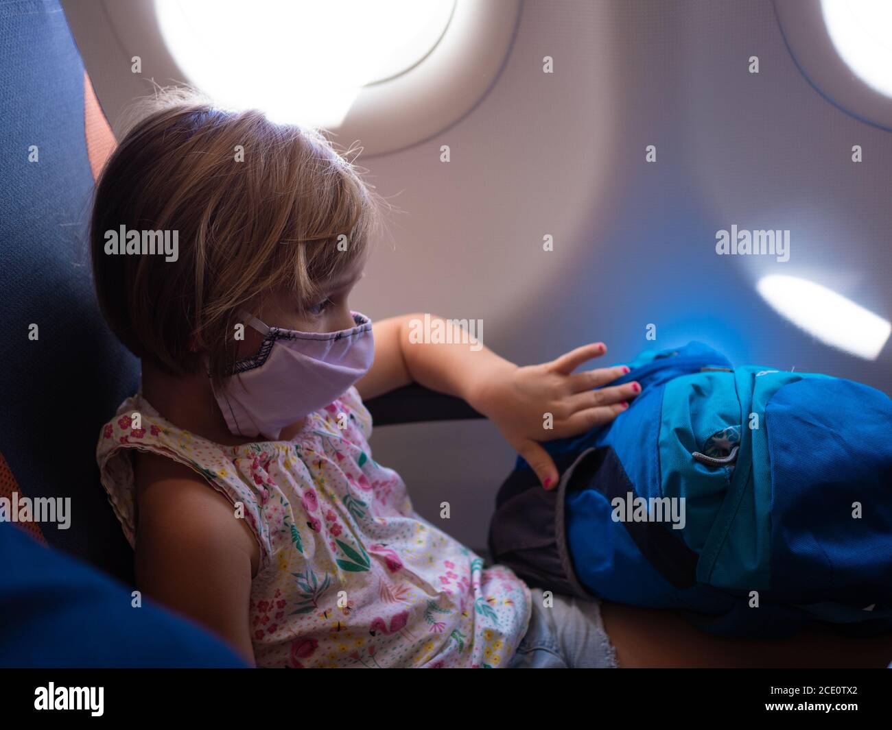 Little girl with mask sitting in airplane Stock Photo Alamy