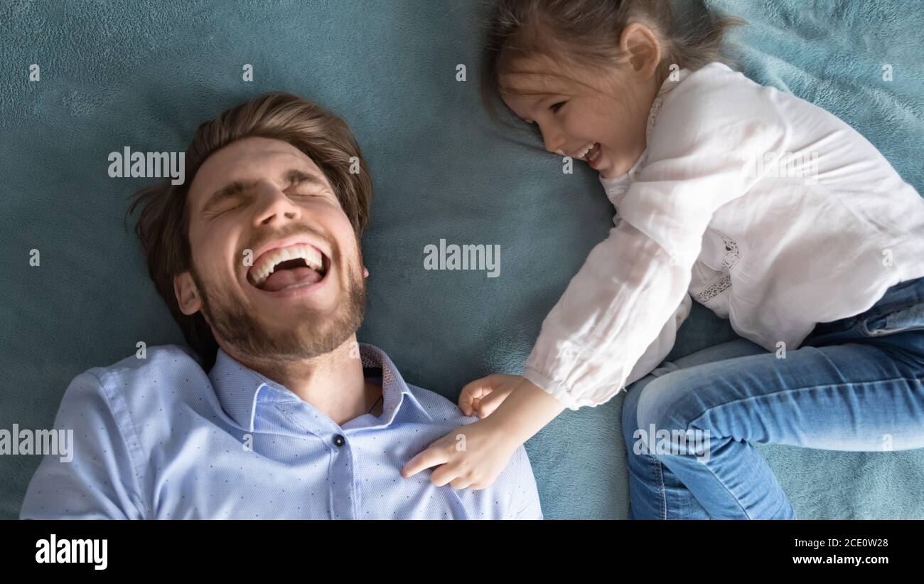 Happy little baby girl tickling laughing young father. Stock Photo