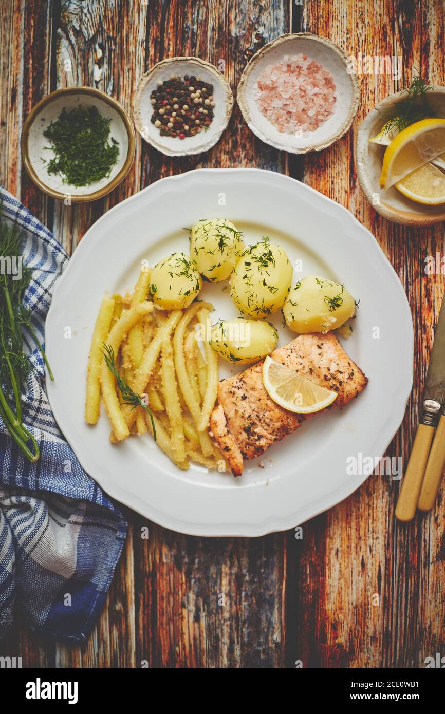 Fresh and tasty baked salmon served with young boiled potatoes and yellow bean. Stock Photo