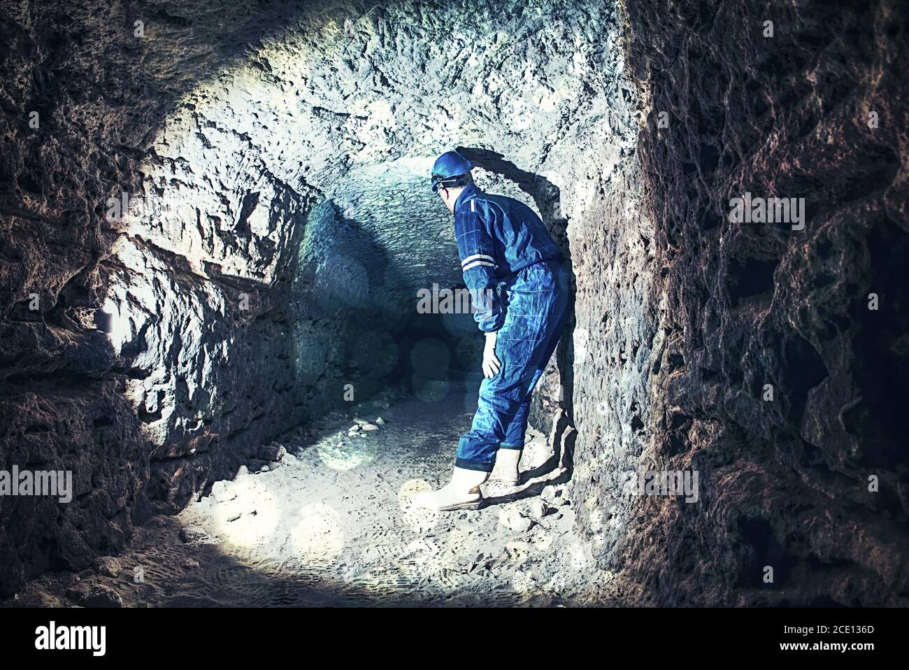 Abstract.  Man in dark old tunnel, indoor shoot. Stairs to the tunnel Stock Photo