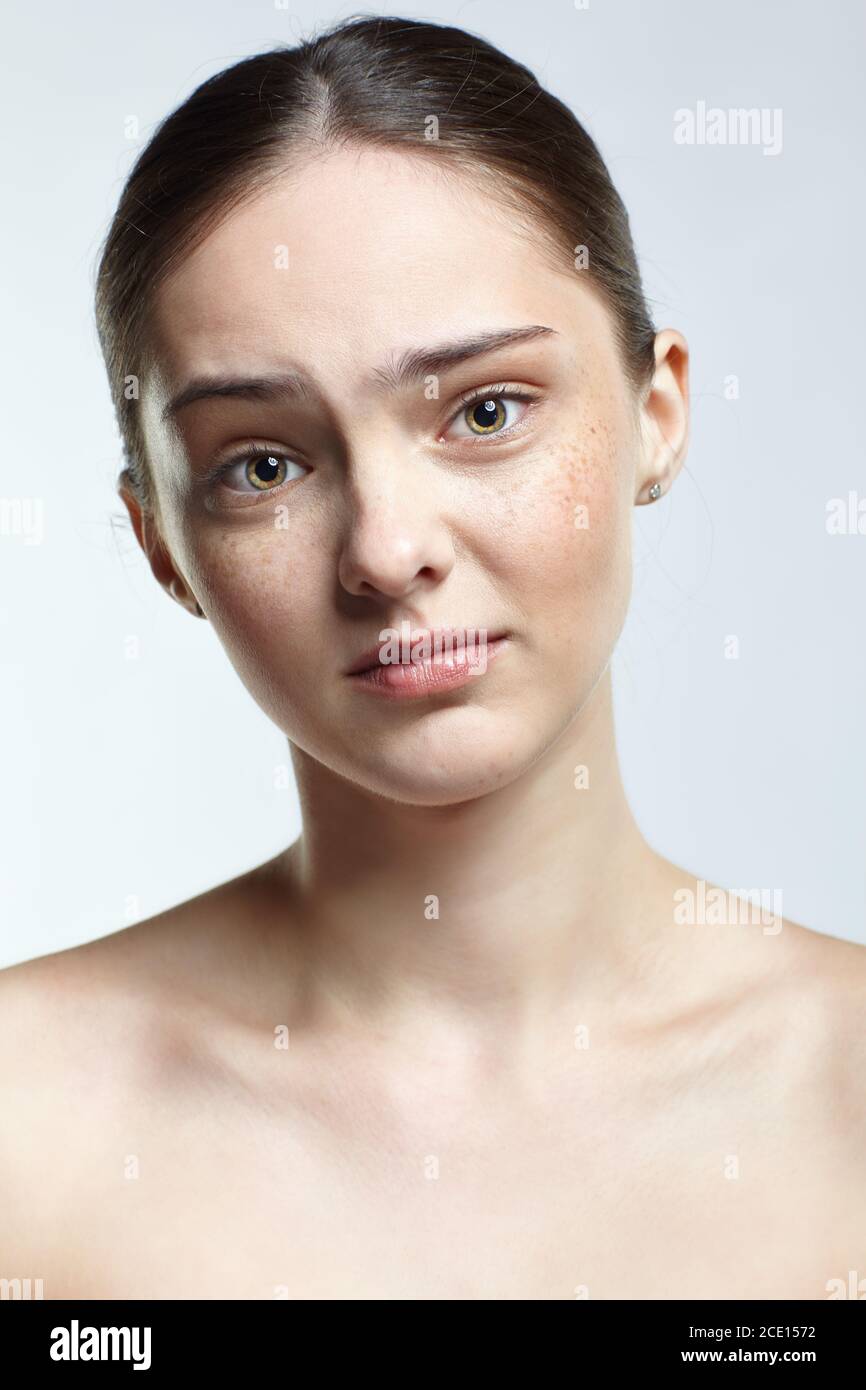 Headshot of emotional female face portrait with regretful, facial expression. Stock Photo