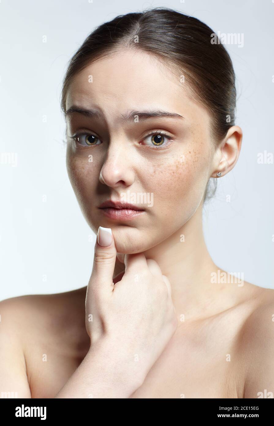 Headshot of emotional female face portrait with unhappy misunderstanding facial expression. Stock Photo