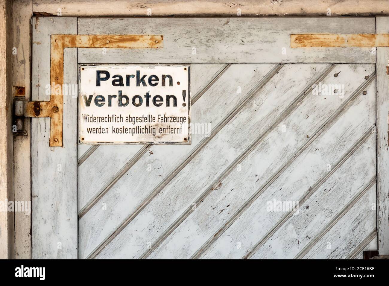 private no parking sign with german text Illegally parked vehicles will be towed at the owner's expense Stock Photo