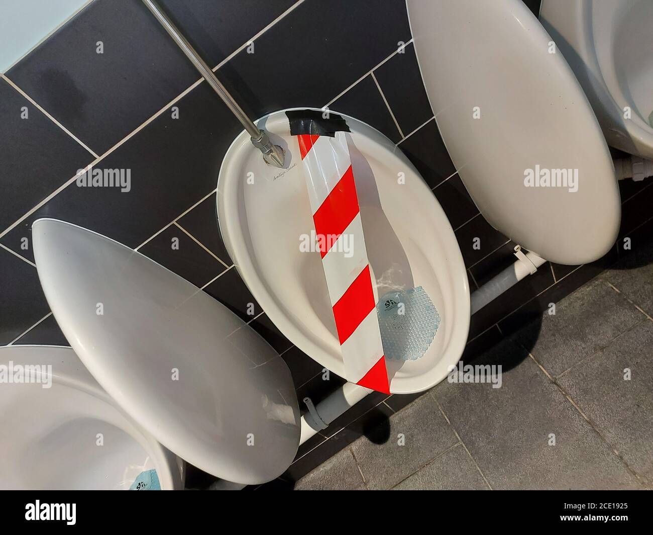 Urinals marked as out of order with safety tape Stock Photo - Alamy
