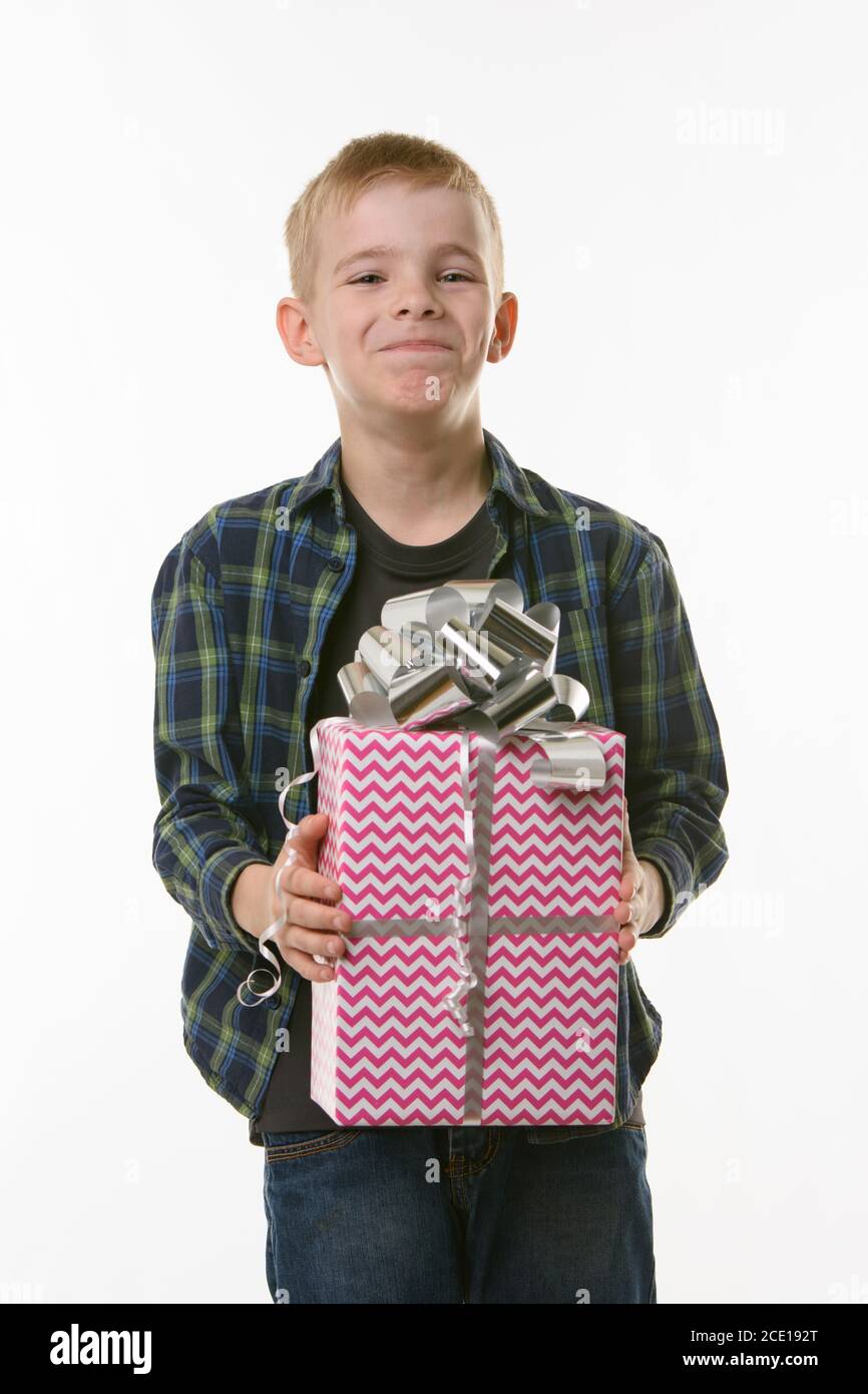 The boy laughs at the present, holding it in his hands Stock Photo