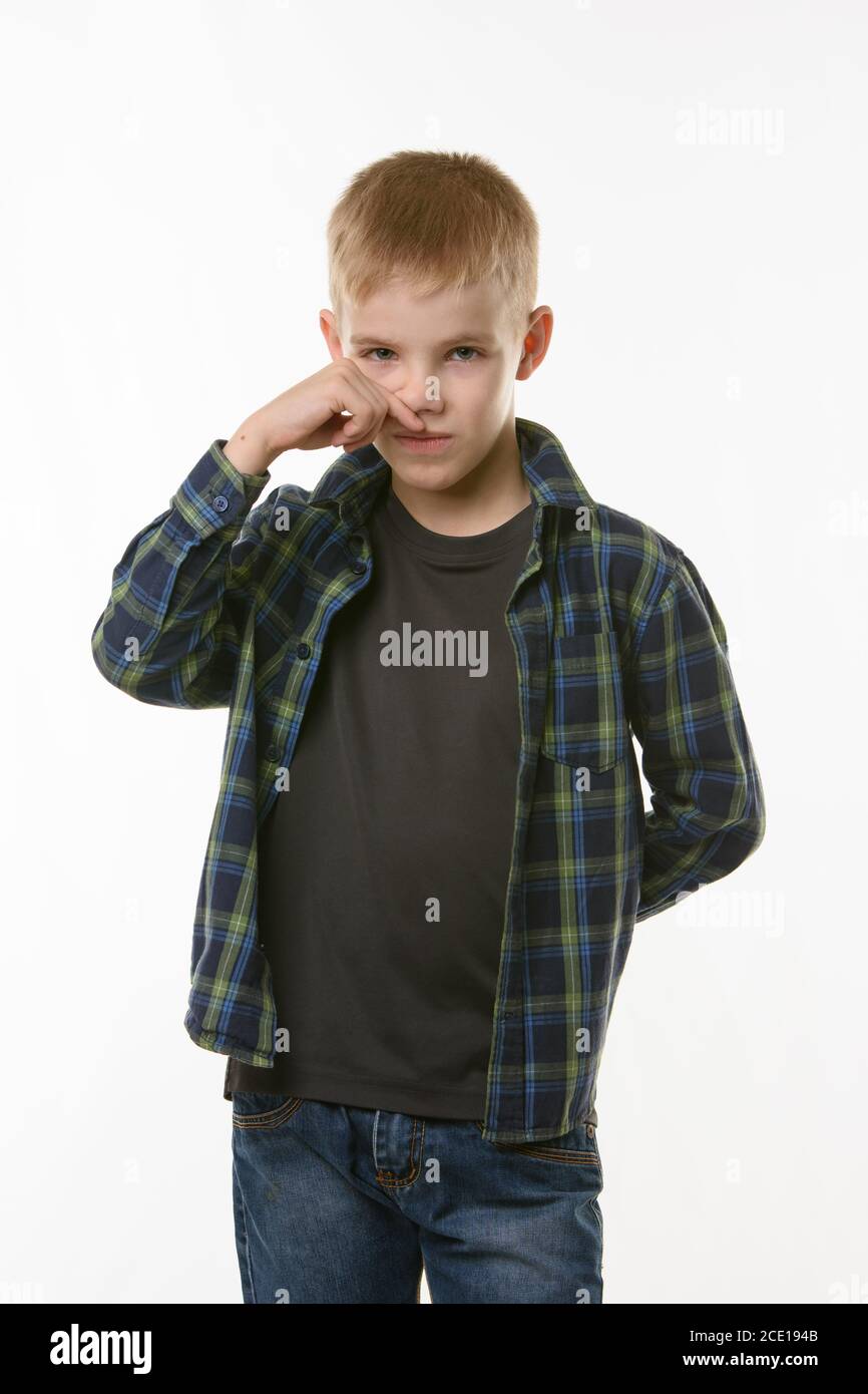A ten year old boy wipes his nose with his finger Stock Photo