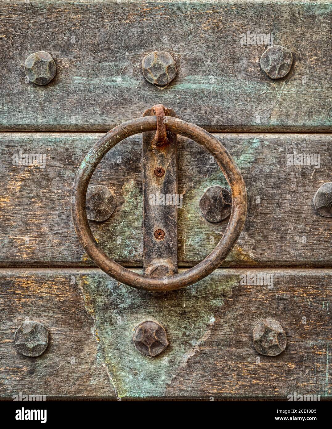 Vintage rusty rounded  iron door handle close up macro image with background of wooden door Stock Photo