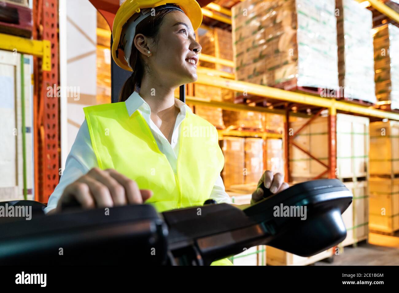 Asian warehouse worker with forklift in warehouse Stock Photo