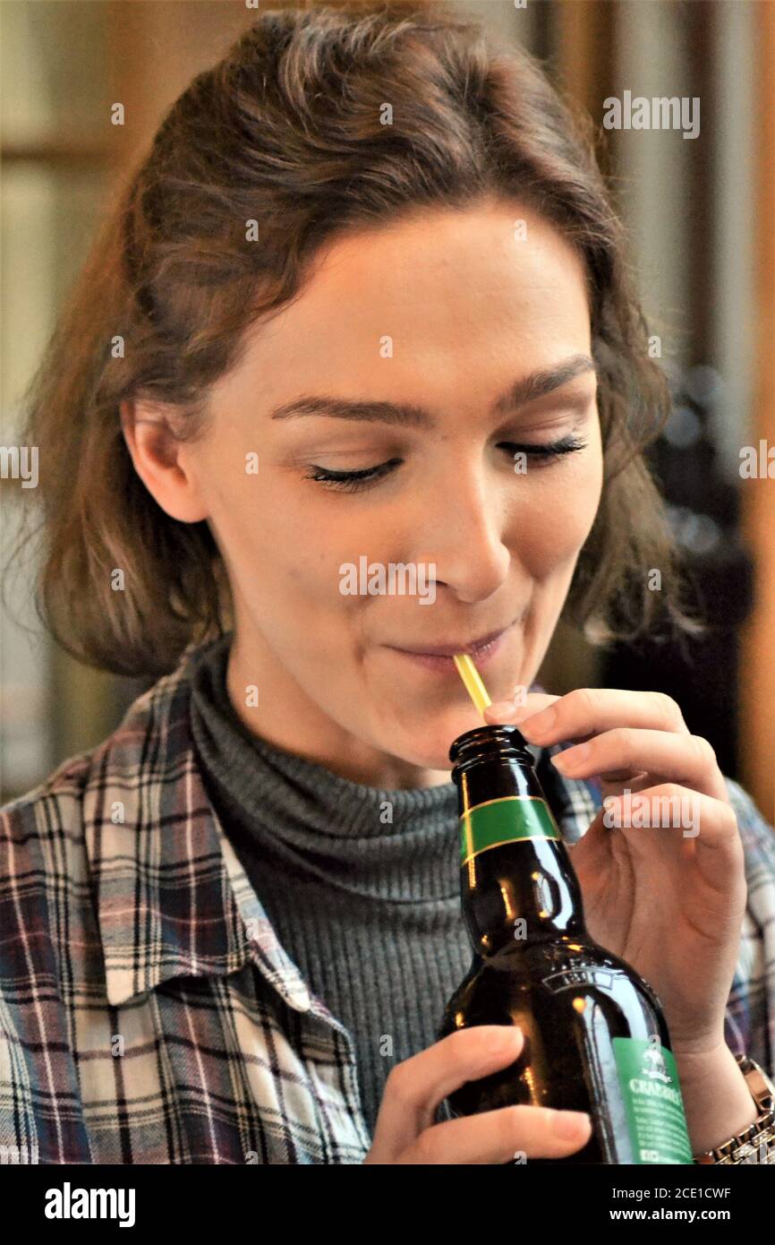 Young woman drinking out of a straw Stock Photo