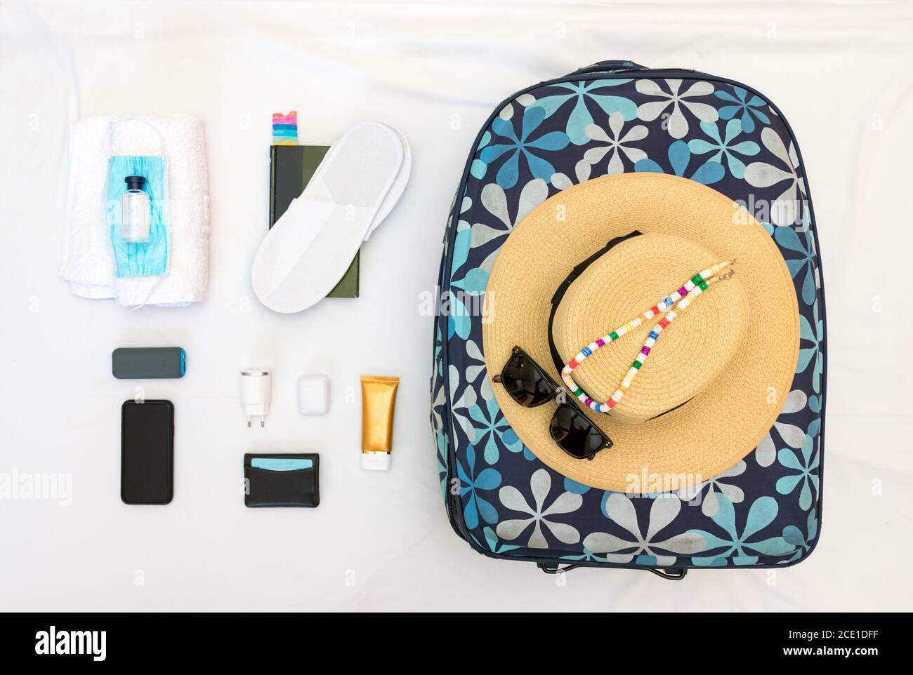 Knolling women travel set with mask, hand sanitiser, straw hat, sunglasses and accessories. Stock Photo