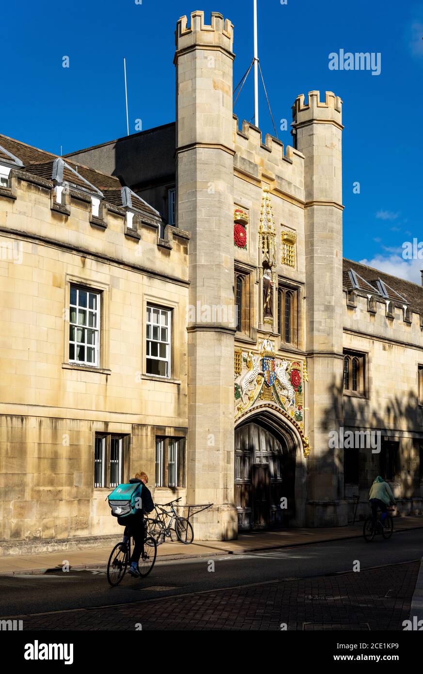 Deliveroo in University City - Deliveroo Cambridge - a Deliveroo food delivery courier passes historic Christs College (1437) in Central Cambridge UK Stock Photo