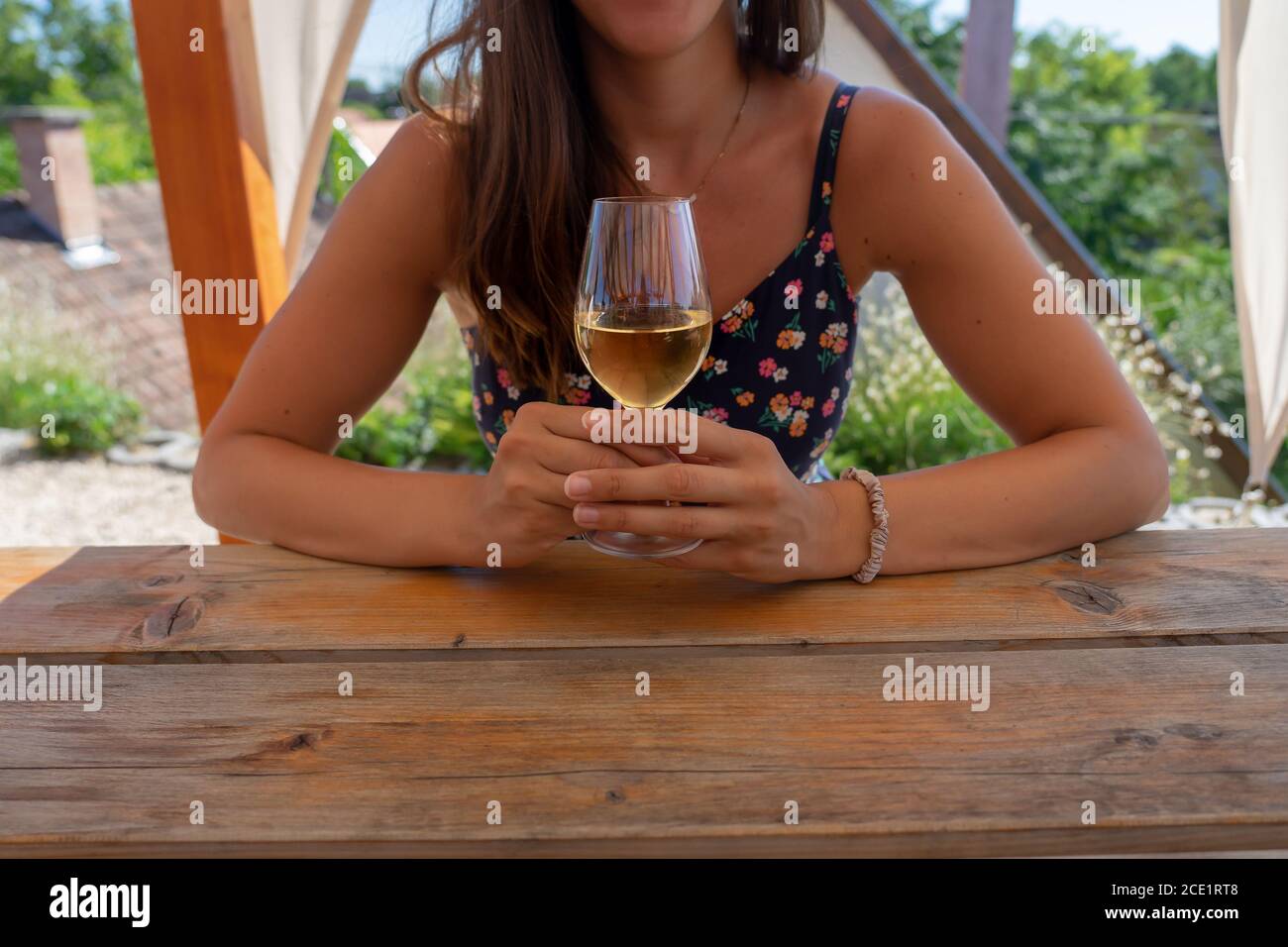 woman sitting nest to the table with a white wine glass Stock Photo