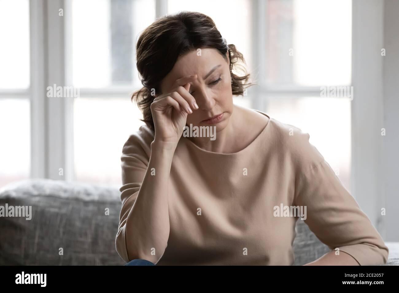 Stressed middle aged woman worrying about hard life situation. Stock Photo