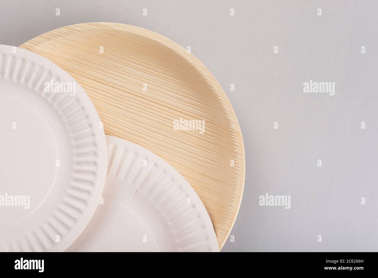 Disposable plates made of paper and palm leaves on light background