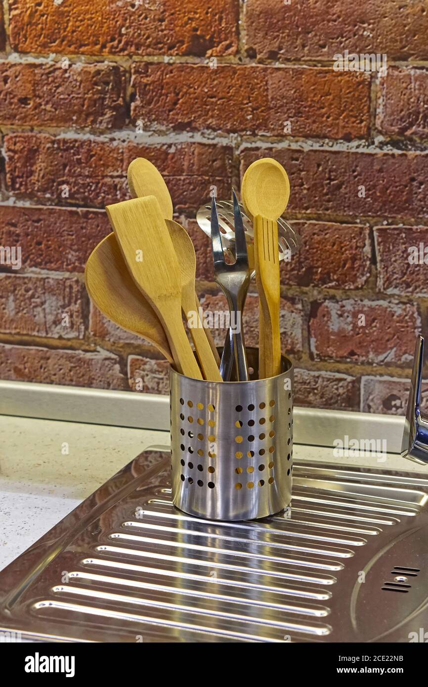 Can of kitchen utensils at stainless steel sink Stock Photo