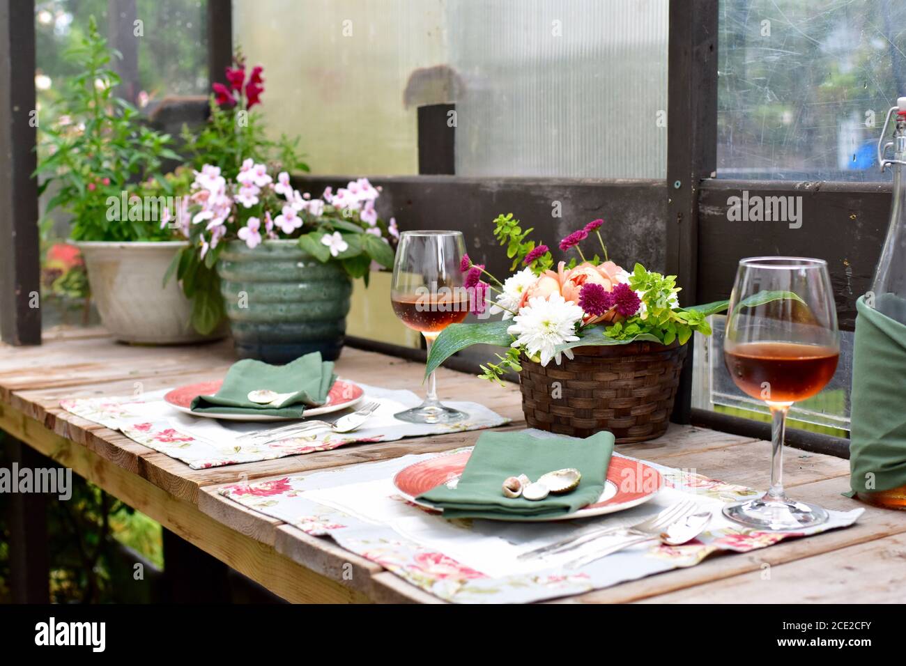 Secluded outdoor patio dining cafe with beautiful rustic garden decor for romantic summer evening dinner Stock Photo