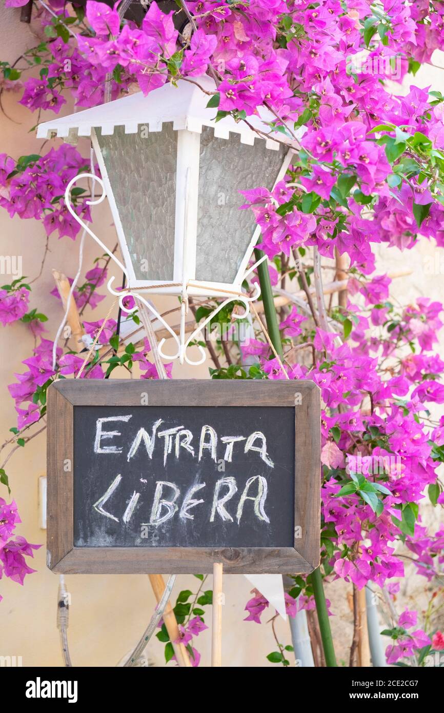 Free entrance sign (entrata libera) with bougainvillea in the old town of Finalborgo, Finale Ligure, Liguria, Italy Stock Photo