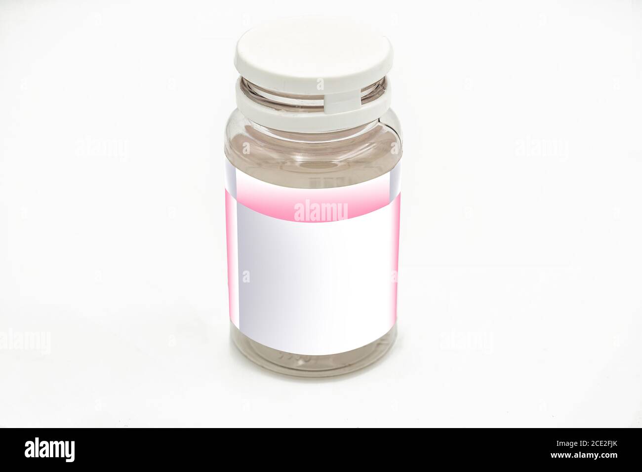 An empty pill bottle with white and pink label mockup, on a white background, ideal for pharmaceutical and research use Stock Photo