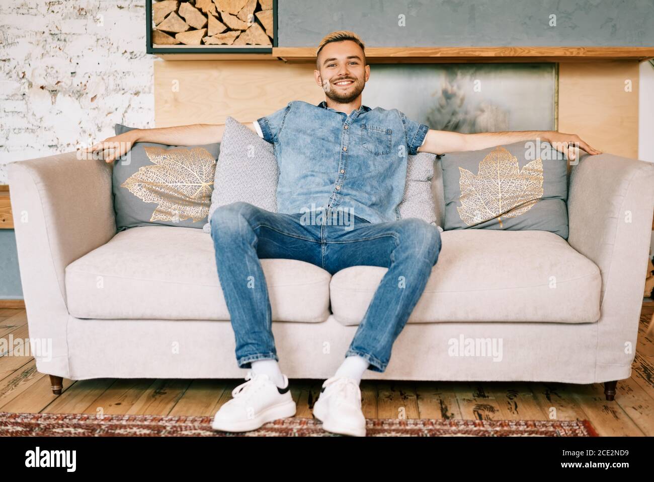 Handsome smiling man relax on sofa at home Stock Photo