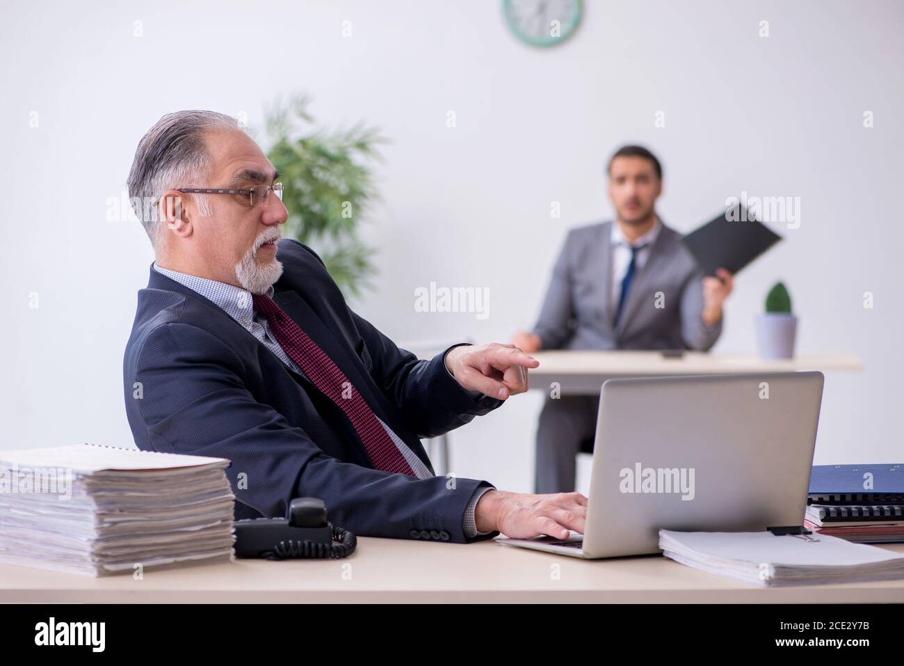 Old boss and his assistant working in the office Stock Photo - Alamy