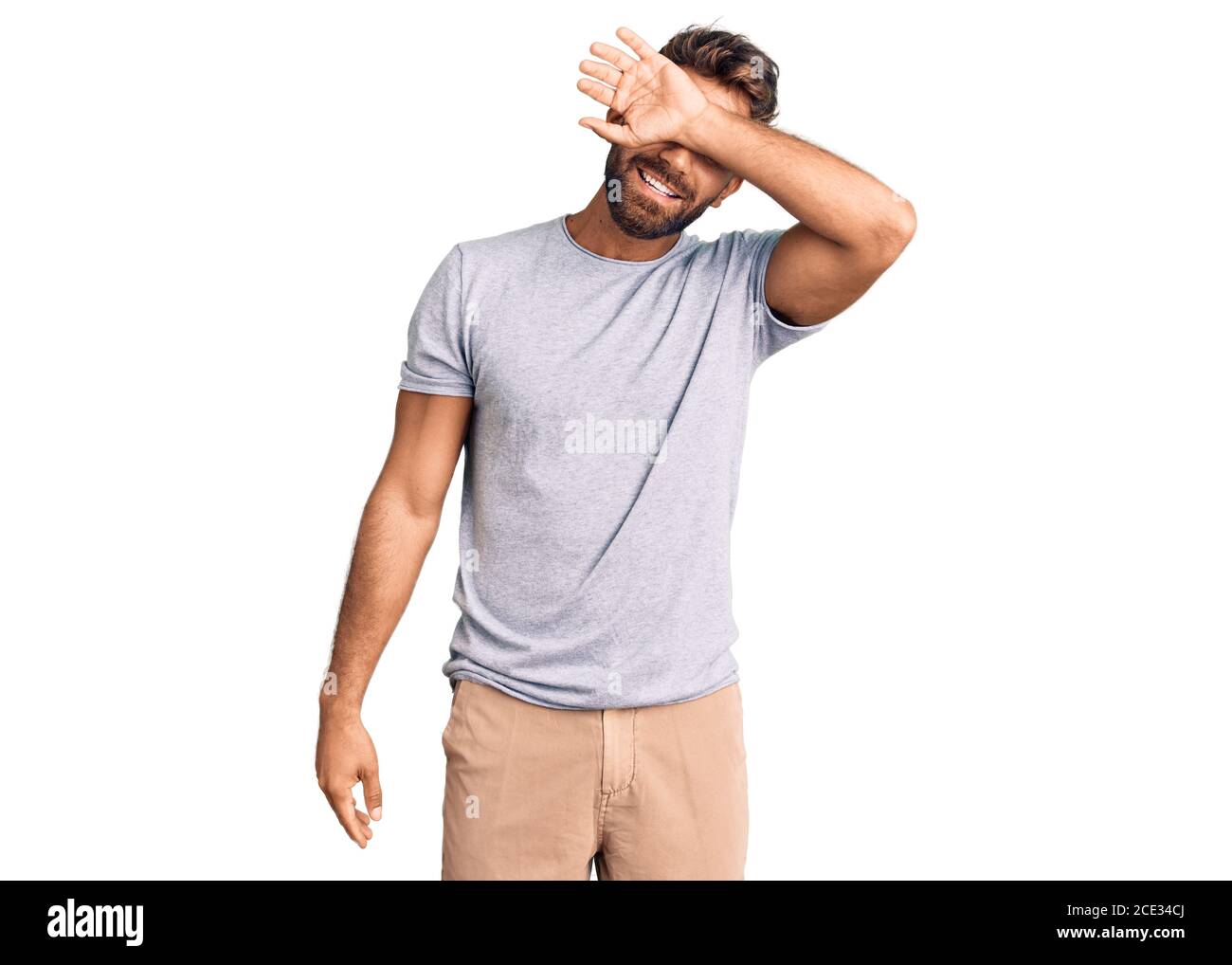 Young hispanic man wearing casual clothes covering eyes with arm ...