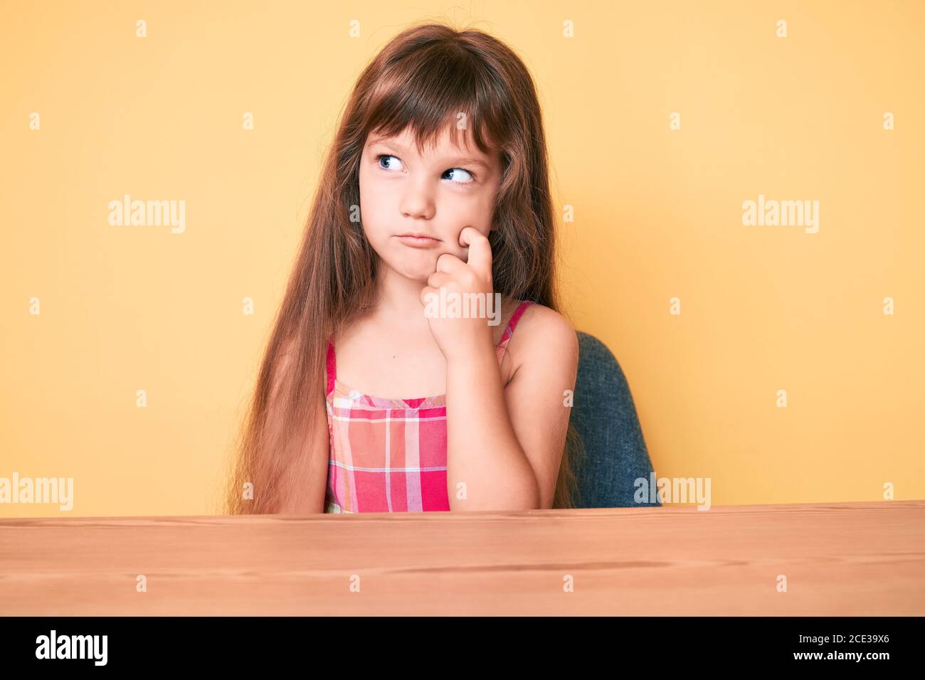 Little caucasian kid girl with long hair wearing casual clothes sitting ...