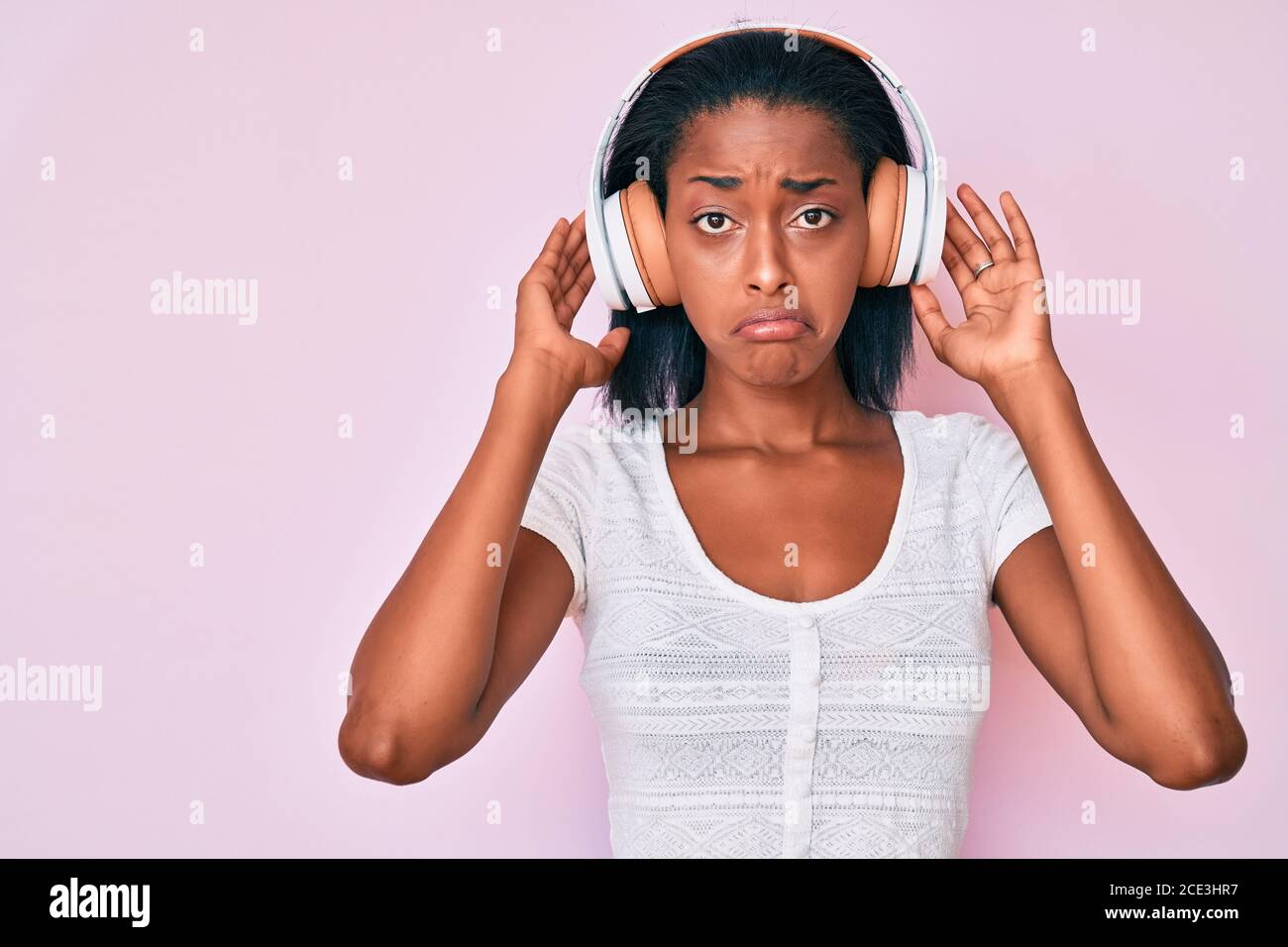 Young african american woman listening to music using headphones depressed  and worry for distress, crying angry and afraid. sad expression Stock Photo  - Alamy